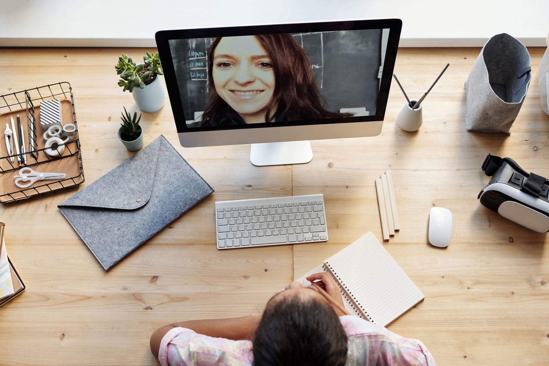 A student attending an online lesson at a desktop computer