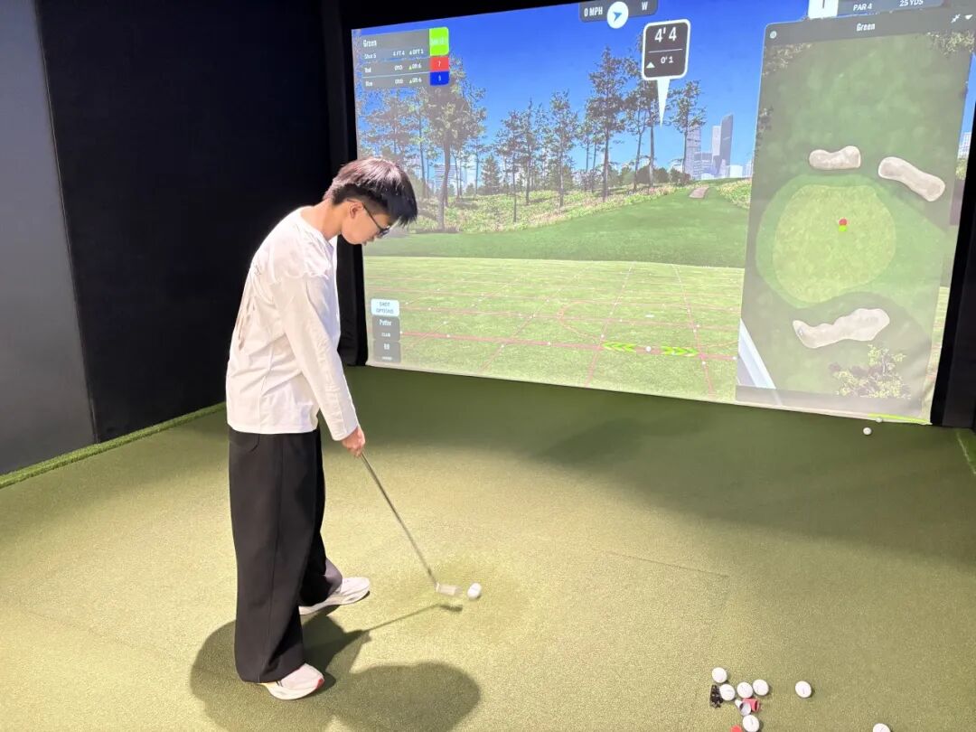 Student practicing on an indoor golf simulator
