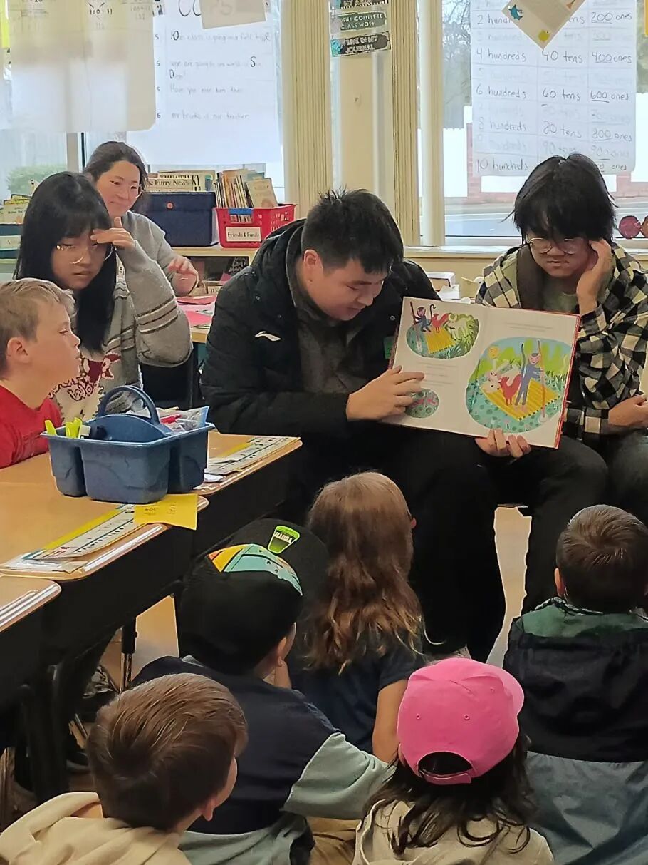 Student reading with children at a local kindergarten