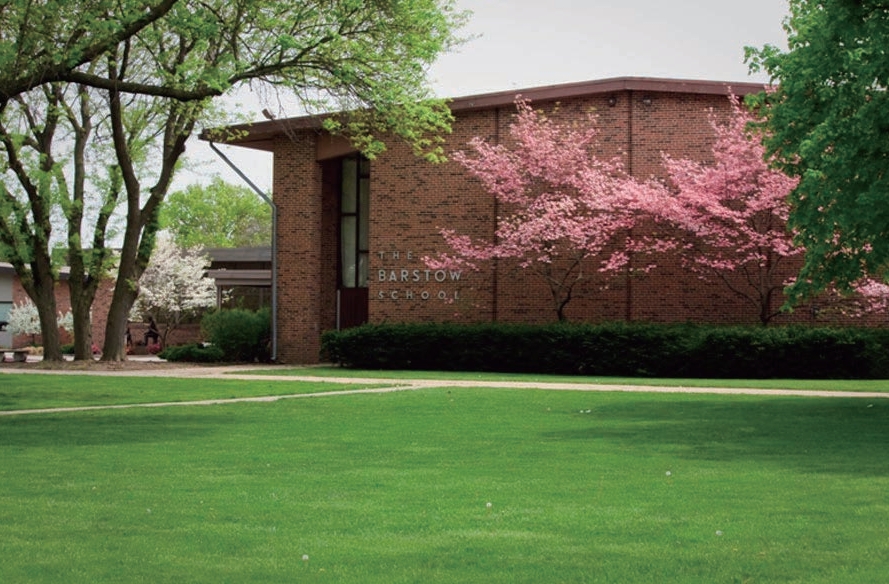 The Barstow School building framed by trees and spring flowers