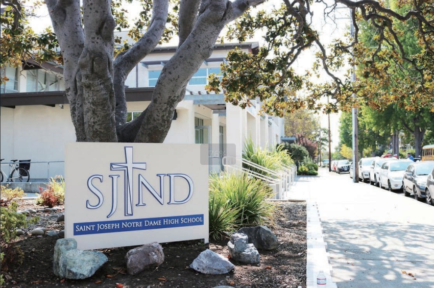 Saint Joseph Notre Dame campus sign and tree-lined street